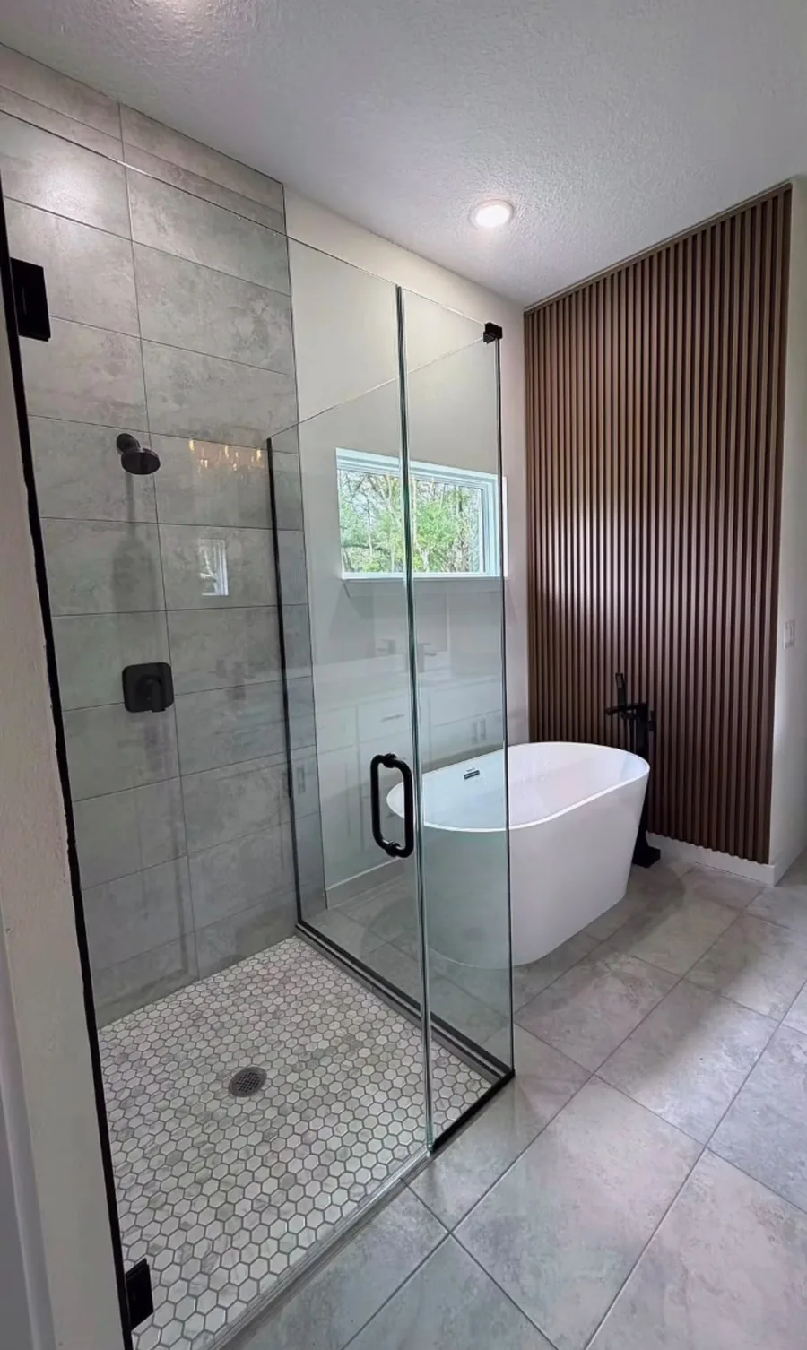 Walk-in shower with black frame and wood slat wall